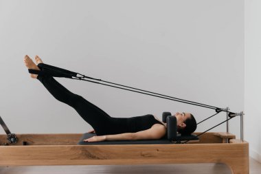 Pilates yenilikçi eğitim makinesi. Spor salonunda spor yapan bir kadın. Yüksek kalite fotoğraf