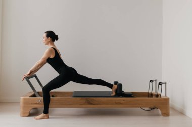 Pilates yenilikçi eğitim makinesi. Spor salonunda spor yapan bir kadın. Yüksek kalite fotoğraf