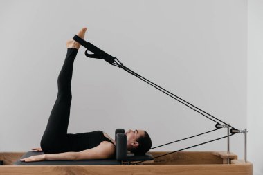 Pilates yenilikçi eğitim makinesi. Spor salonunda spor yapan bir kadın. Yüksek kalite fotoğraf