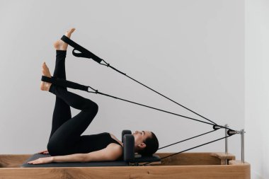 Pilates yenilikçi eğitim makinesi. Spor salonunda spor yapan bir kadın. Yüksek kalite fotoğraf