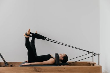 Pilates yenilikçi eğitim makinesi. Spor salonunda spor yapan bir kadın. Yüksek kalite fotoğraf
