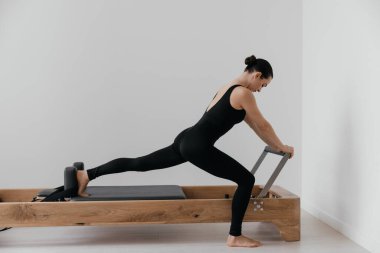 Pilates yenilikçi eğitim makinesi. Spor salonunda spor yapan bir kadın. Yüksek kalite fotoğraf