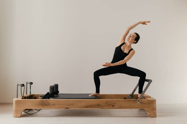 Pilates reformer training machine. sporty woman exercising gym. High quality photo