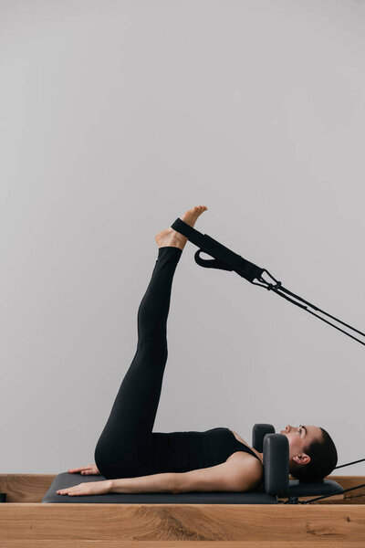 Pilates reformer training machine. sporty woman exercising gym. High quality photo