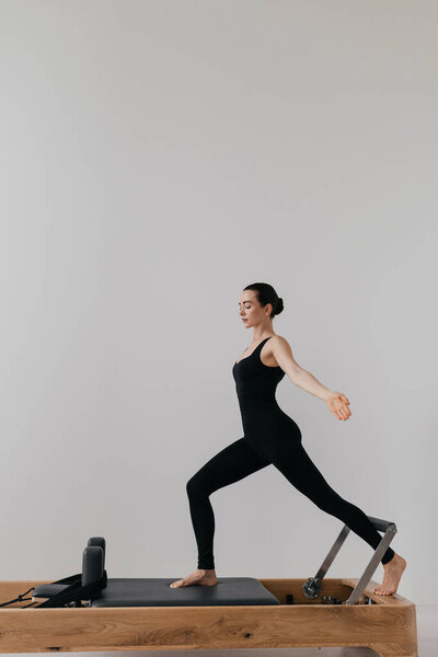 Pilates reformer training machine. sporty woman exercising gym. High quality photo