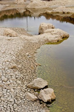 Kuruyan bir gölün kıyısındaki çatlak toprak..