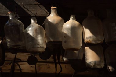 Jerome, Arizona 'da bir binanın tavanında asılı duran eski cam sürahiler..