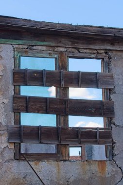 Jerome, Arizona 'nın hayalet kasabasındaki eski bir pencereye tahta çakılmış. Gökyüzü tahtaların arasından görülebilir..