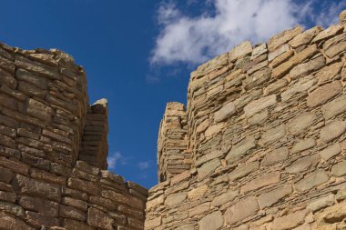 New Mexico, Aztek Pueblo 'daki duvarlar mavi gökyüzünde bulutlarla.