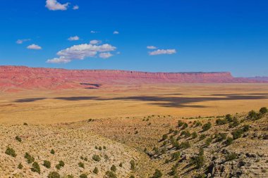 Arizona 'daki Büyük Kanyon' un kuzey şeridi yakınlarındaki 89 no 'lu eyalet yolundan House Rock Valley' in manzarası. Vermillion Kayalıkları uzakta. Bulutlar ovaya gölge düşürür.