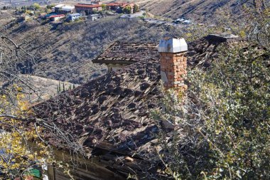 Yeni bir çatıya ihtiyacı olan terk edilmiş eski bir ev. Jerome, Arizona 'da. Arka planda eski Jerome Lisesi var. Jerome, Arizona.