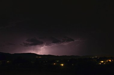 Arizona 'da bir fırtına sırasında yıldırım düştü. Şehir ışıkları ön planda..