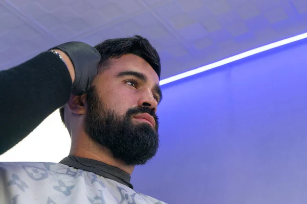 Berber, Amerikan çocuğuna saç kesiyor. Berber saç makasıyla saç kesenin arkasında durur.