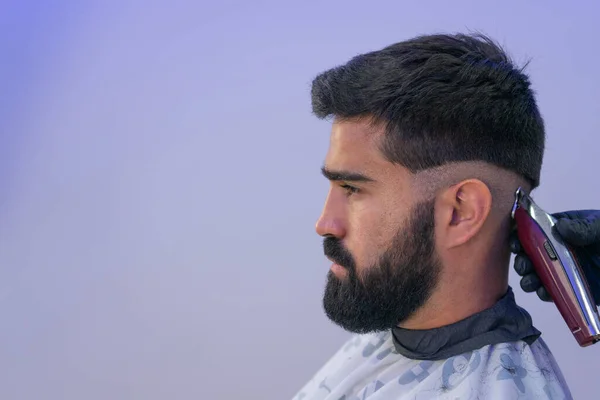 Berber, Amerikan çocuğuna saç kesiyor. Berber saç makasıyla saç kesenin arkasında durur.