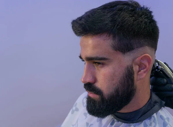 Berber, Amerikan çocuğuna saç kesiyor. Berber saç makasıyla saç kesenin arkasında durur.