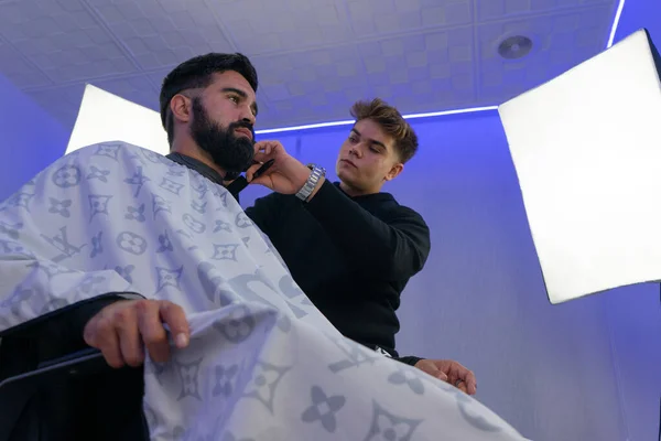 Berber, Amerikan çocuğuna saç kesiyor. Berber saç makasıyla saç kesenin arkasında durur.