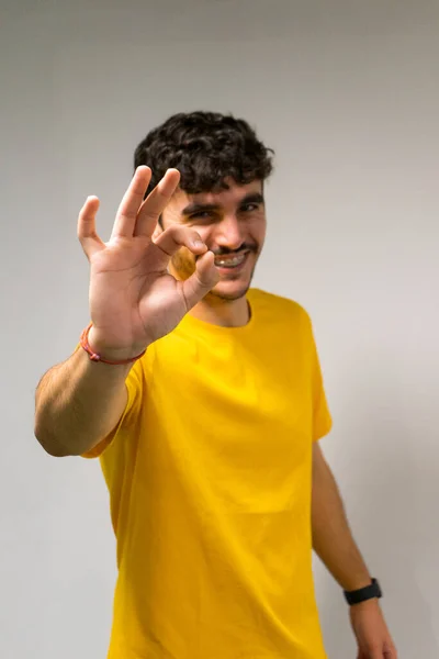 Beyaz, beyaz, kıvırcık saçlı, sarı tişörtlü, kendine güvenen, izole beyaz arka planlı beyaz çocuk.