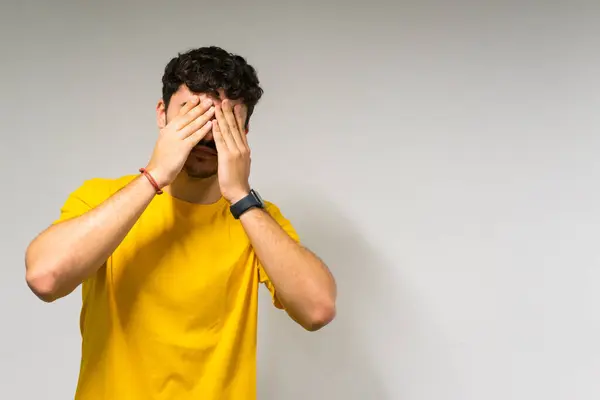 Beyaz, beyaz, kıvırcık saçlı, sarı tişörtlü, izole beyaz arkaplan üzerine kapalı gözlü beyaz çocuk.