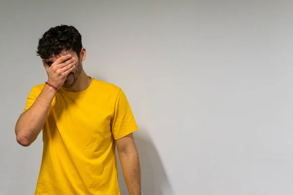 Beyaz, beyaz, kıvırcık saçlı ve sarı tişörtlü çocuk izole edilmiş beyaz arka planda gülüyor.