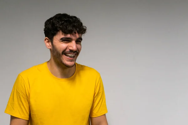 Beyaz, beyaz, kıvırcık saçlı ve sarı tişörtlü çocuk izole edilmiş beyaz arka planda gülüyor.