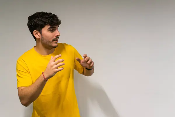 Beyaz, beyaz, kıvırcık saçlı ve sarı tişörtlü çocuk izole edilmiş beyaz arka plana şaşırmış.