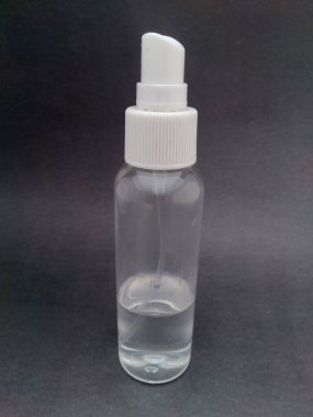 Siyah arka planı olan el dezenfektanı şişesi.