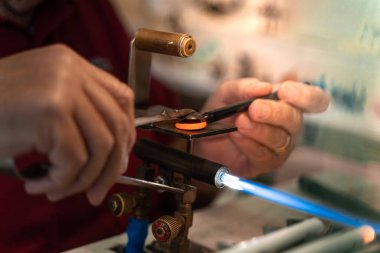 Murano cam üfleme fabrikası. İşçiler cam işlenebilsin diye ocağa demir çubuk koydular. Sanatçı sıcak camı gaz alevleriyle şekillendirdi. Sanatçı cam vazolar ve heykeller yapıyor. Venedik kışı. Geleneksel bir fırında cam eriyor..