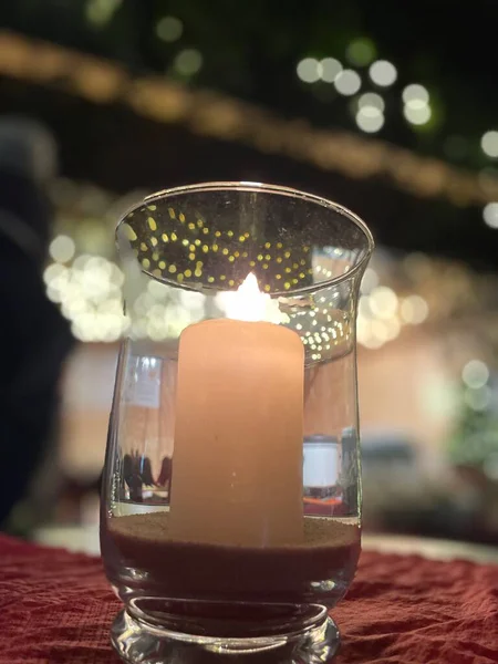 close-up of a white candle on a table with bokeh. christmas and new year decor