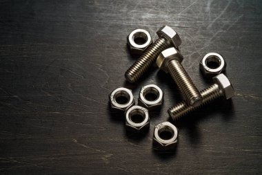 Çelik somunlar ve cıvatalar koyu arkaplanı kapatır