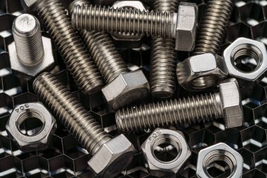 Koyu arkaplanda çelik somunlar ve cıvatalar