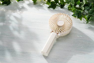 Tahta masada taşınabilir elektrikli vantilatör.