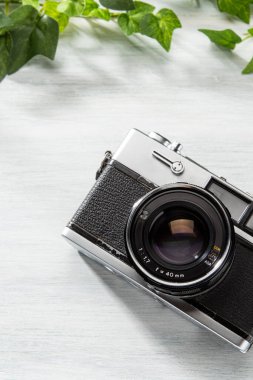 Old film camera isolated on wooden table clipart