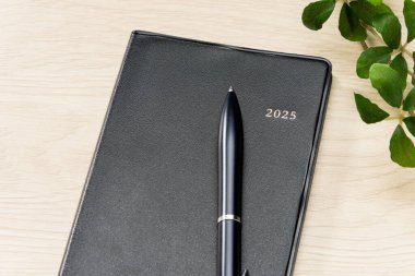 2025 Defter ve kalem ahşap masa üzerinde (2025 zaman çizelgesi)