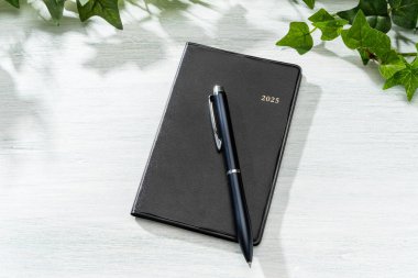 2025 Defter ve kalem ahşap masa üzerinde (2025 zaman çizelgesi)