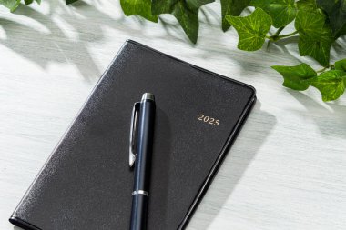 2025 Defter ve kalem ahşap masa üzerinde (2025 zaman çizelgesi)