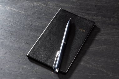 2025 Defter ve kalem ahşap masa üzerinde (2025 zaman çizelgesi)