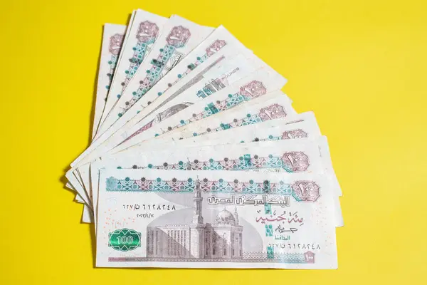 stock image Stack of Egyptian 100 Pound Banknotes on a Yellow Background