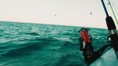 Açık denizde maceraya hazır bir teknede kurulmuş dinamik bir olta manzarası. Bu görüntü derin deniz balıkçılığının özünü yakalar, sabrı, yeteneği ve doğada geçirilen günün heyecanını sembolize eder..