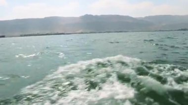 Al Sokhna, Mısır yakınlarındaki Süveyş Körfezi 'nin ferahlatıcı manzarası, ön planda hafif dalgalar ve arka planda görkemli bir şekilde duran Al Ataqa Dağı. Güneş ışığı sudan yansıyarak, sahneye ışıldayan bir etki katar.. 