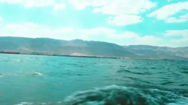 Al Sokhna, Mısır 'daki Süveyş Körfezi, arka planda dağınık bulutlarla yükselen Ataqa Dağı' nı gözler önüne seriyor. Dalgalar nazikçe yüzeye çarpar, Kızıl Deniz 'in kıyı güzelliğinin özü ve haşin Mısır manzarası..