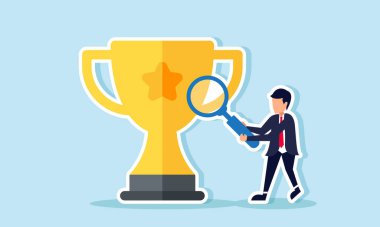 Bir iş adamı, bir büyüteç kullanarak bir kupayı gözlemler. En iyi iş yeri olmak için stratejileri analiz eder.