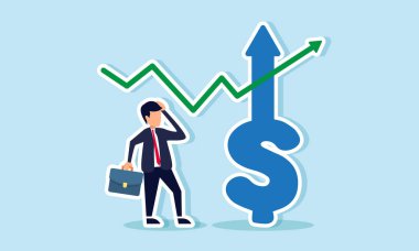 Yükselen bir dolar grafiğinin yanında duran işadamı, kafası karışık görünüyor, önemli ticari kazanç ve satışların artmasına şaşırdığını gösteriyor.