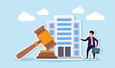 Bir işadamı bir iş yeri binası ve tokmağın yanında duruyor. Şirket varlıklarının korunmasında hukuki güvencenin bir göstergesi.