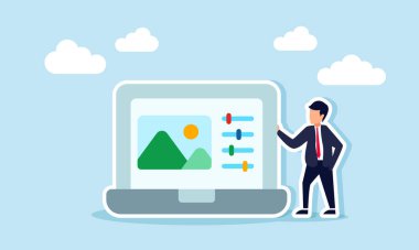 Bir iş adamı, reklam amaçlı poster tasarımı ve ayarlama araçlarıyla bir resmi gösteren bir dizüstü bilgisayarın yanında duruyor.