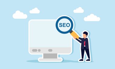 İş adamı monitörün yanında elinde SEO sözcüğüyle bir büyüteç tutuyor. İş performansını ve büyümeyi optimize etmek için SEO uygulamasının bir göstergesi.
