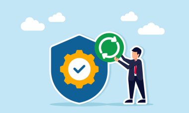 İş adamı, üzerinde dişli ve işaret olan bir kalkanın yanında sürekli bir sembol tutuyor. Çalışma korumanın ve sigortanın devam ettiğini gösteriyor.