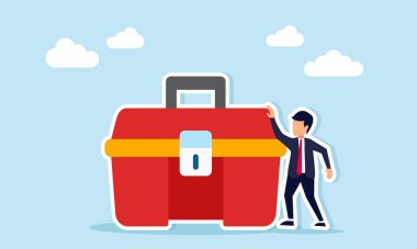 Bir alet çantasının yanında duran işadamı, iş veya endüstriyel ortamlarda bakım için hazır olduğunun bir göstergesi