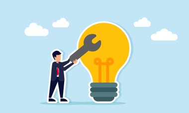 İş adamı elinde lamba ışığında iş fikri uygulamasının değerlendirilmesinin yanında bir anahtar tutuyor