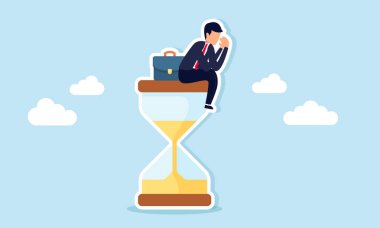 Kum saatinde oturan işadamı, iş teslim tarihine ilişkin hayal kırıklığına uğramış ya da üzgün görünüyor.