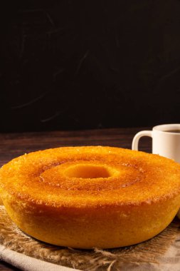 Yellow Brazilian Corn Cake (Bolo de Fuba) and coffee, vertical, copyspace, black background